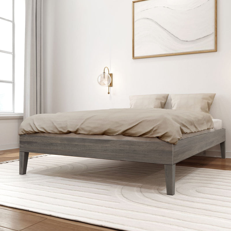 Full Size Platform Bed in Driftwood - angled view styled in a bedroom with tan bedding, a wall sconce, and framed art