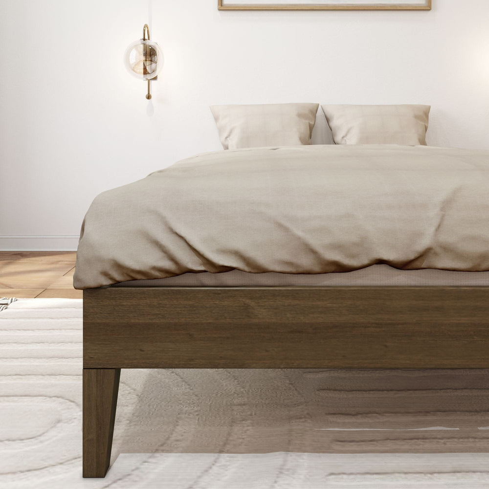 Full Size Platform Bed Walnut Frame Detail Full Size Platform Bed in Walnut - close-up of the solid wood side rail and tapered leg with bedding draped over the frame.