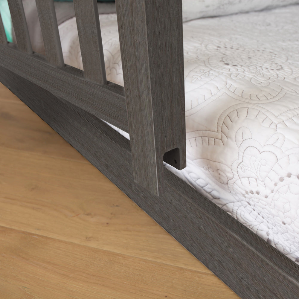 Max and Lily Add on Safety Guard Rail in Clay - close-up of the rail's lower mounting bracket attaching to the bed frame beside the mattress.
