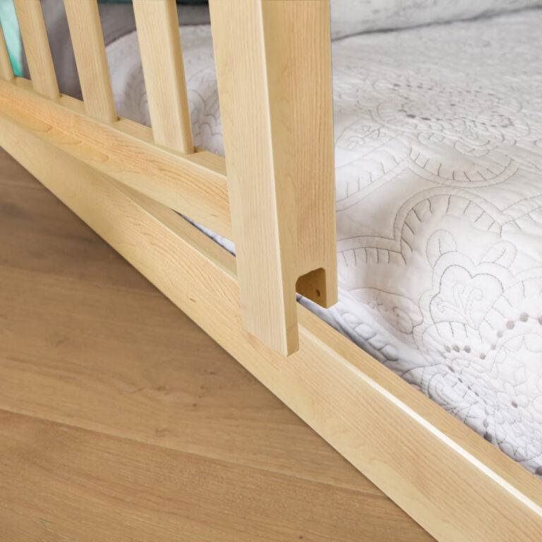 Max and Lily Add on Safety Guard Rail in Natural - close-up of the rail post attaching to the bed frame beside the mattress