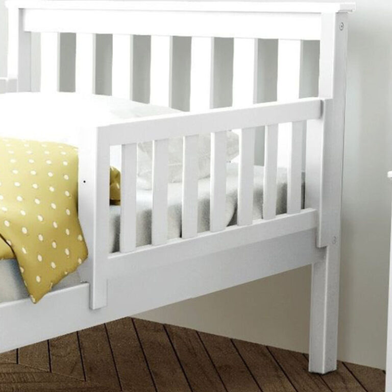 Max and Lily Add on Safety Guard Rail in White - the slatted wooden rail mounted along the side of a bed with the headboard and mattress behind it.