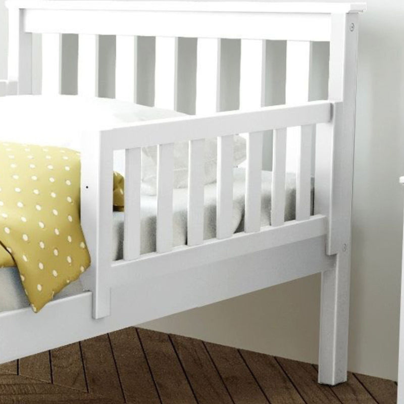 Max and Lily Add on Safety Guard Rail in White - the slatted wooden rail mounted along the side of a bed with the headboard and mattress behind it.