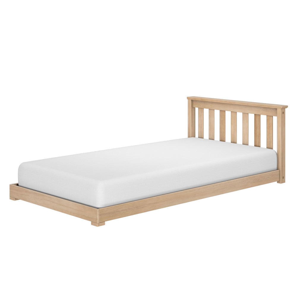 Max and Lily Classic Twin Floor Bed in Blonde - angled view showing the slatted headboard and low platform frame with a white mattress