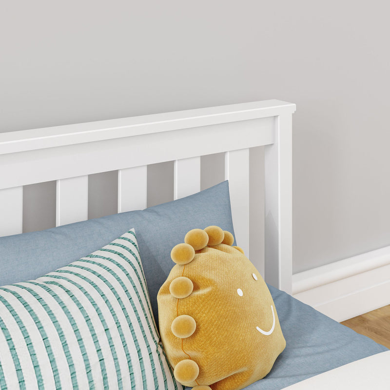 Max and Lily Classic Twin Floor Bed in White - close-up of the slatted headboard with pillows and a plush cushion