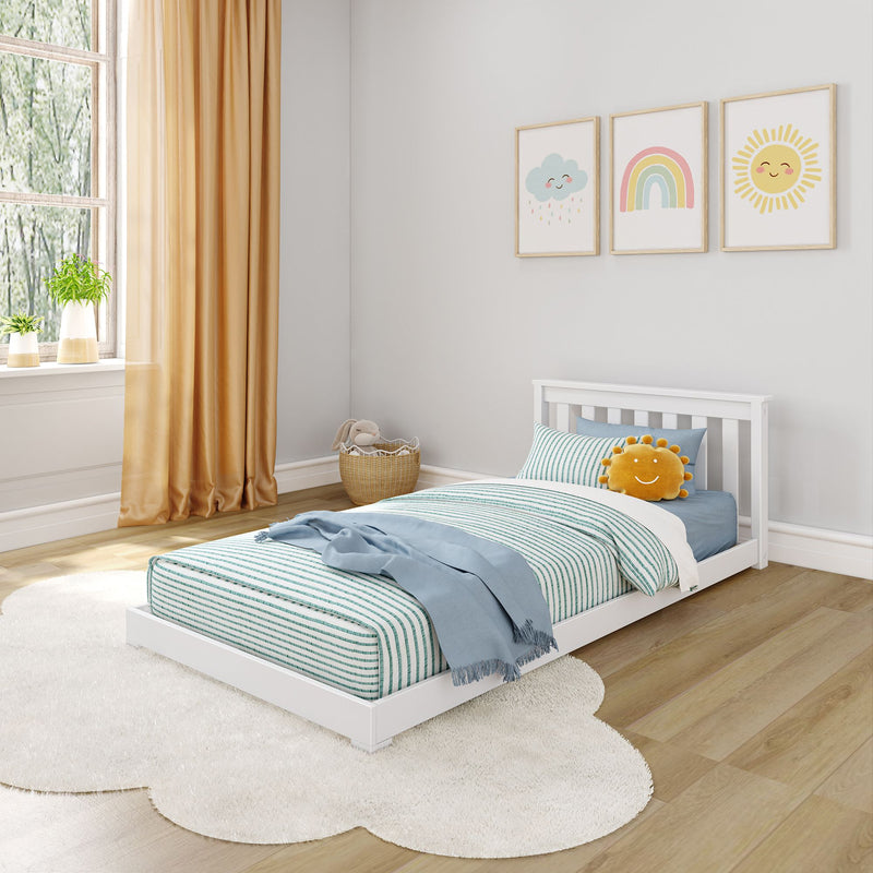 Max and Lily Classic Twin Floor Bed in White - angled view styled in a child's room with striped bedding, yellow curtains and cloud, rainbow and sun wall art