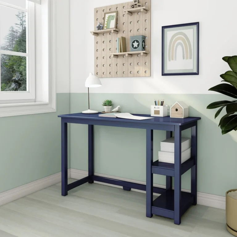 Max and Lily Desk With Shelves in Blue - room scene by a window with the desk styled with a lamp and open shelves.