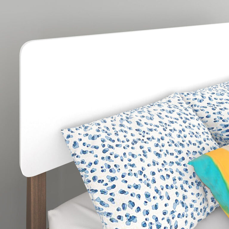Max and Lily Mid-Century Modern Full Bed in White/Walnut - closeup of the curved-corner headboard panel with patterned pillows and a walnut leg visible