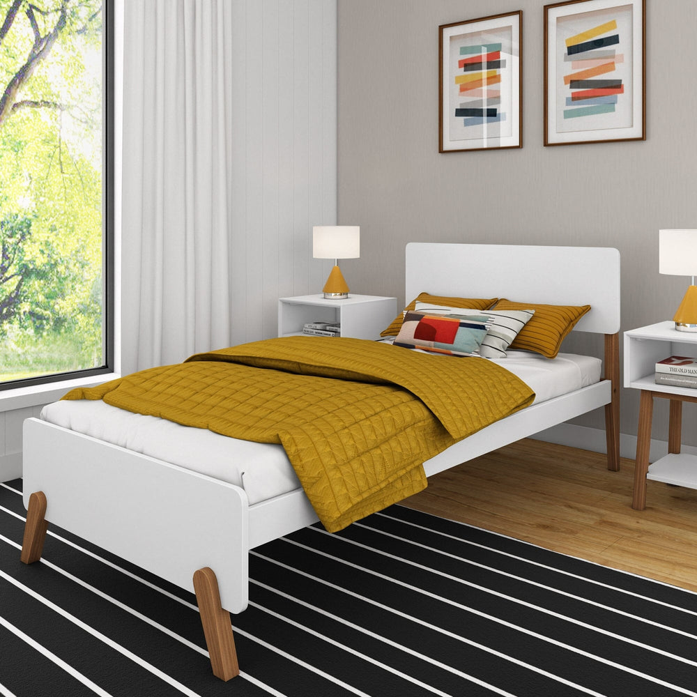 Max and Lily Mid-Century Modern Twin Bed in White/Pecan - angled view in a styled bedroom with mustard bedding, nightstands and angled pecan wood legs on a striped rug