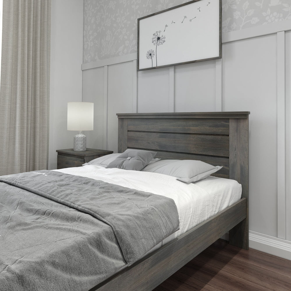 Max and Lily Modern Farmhouse Full Panel Bed in Driftwood - close-up of the plank headboard above grey bedding with a bedside lamp and framed art.