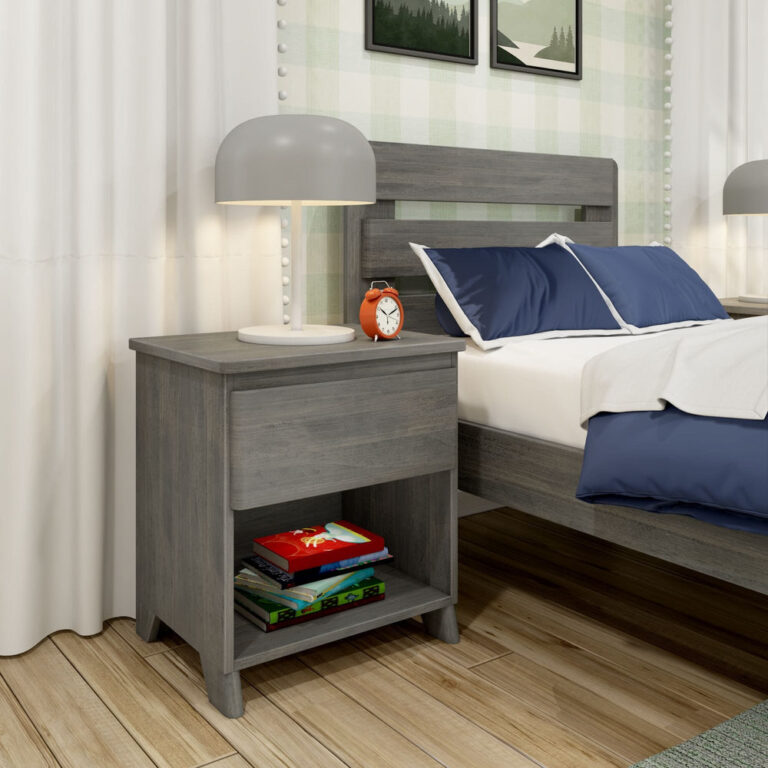 Max And Lily Modern Farmhouse Night Stand Driftwood Room Scene 1 Max and Lily Modern Farmhouse Night Stand in Driftwood - styled beside a bed with a lamp, alarm clock, and books on the open lower shelf.