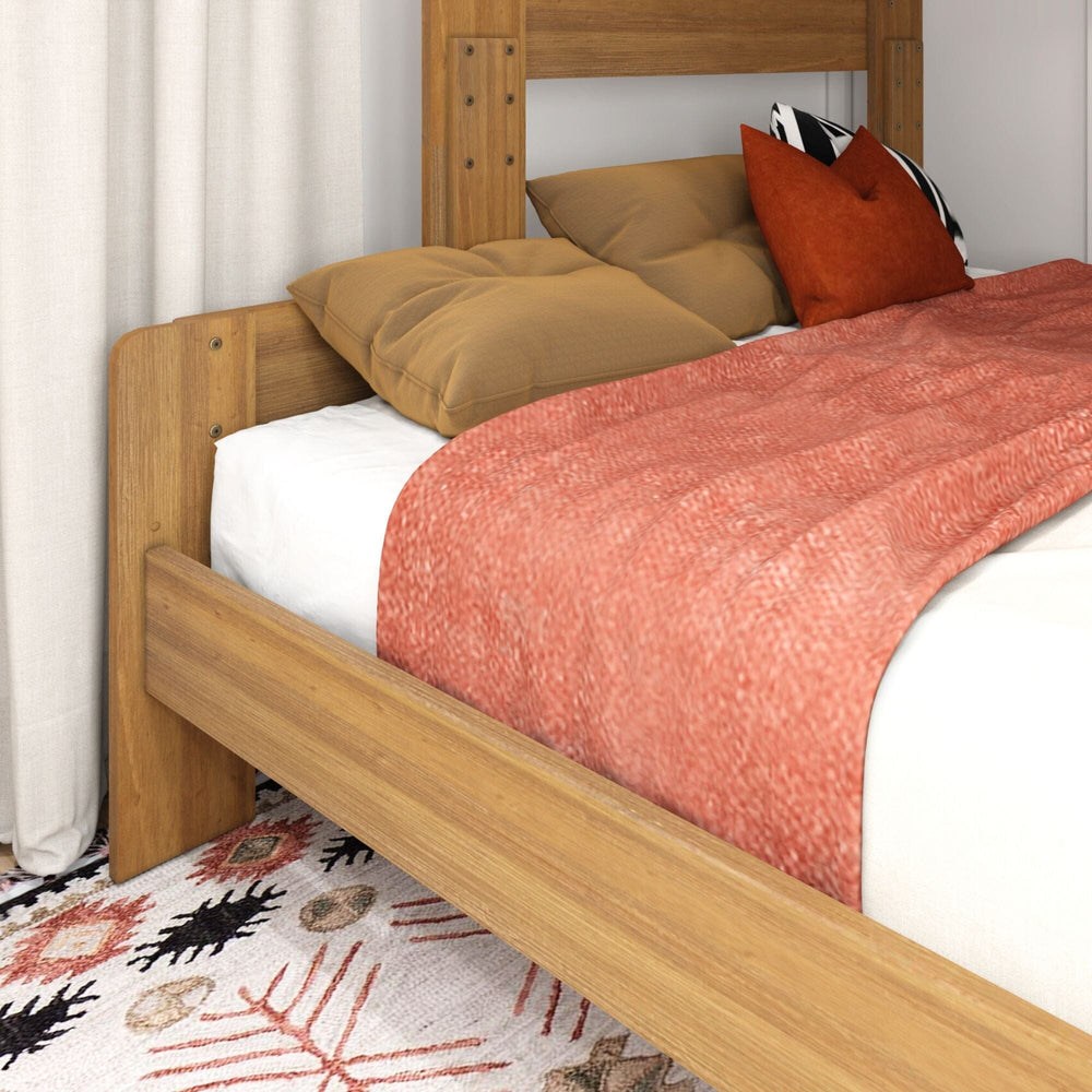 Max and Lily Modern Farmhouse Twin Over Full Bunk Bed in Pecan - close-up of the lower full bed corner with decorative pillows and a throw against the wooden headboard panel.