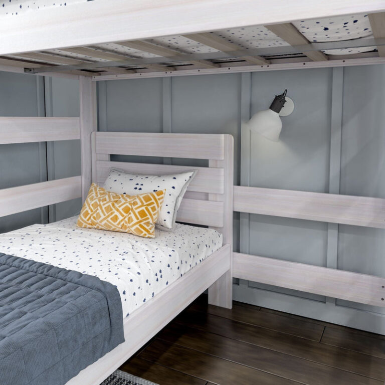 Max and Lily Modern Farmhouse Twin Over Twin L-Shaped Bunk Bed in White Wash - detail of the lower twin bed with headboard and the upper bunk guardrail above.