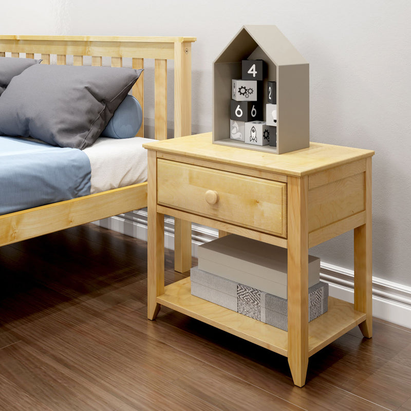Max and Lily Night Stand With Drawer and Shelf in Natural - styled in a bedroom beside a natural wood bed, showing the single drawer and open lower shelf with decorative boxes.