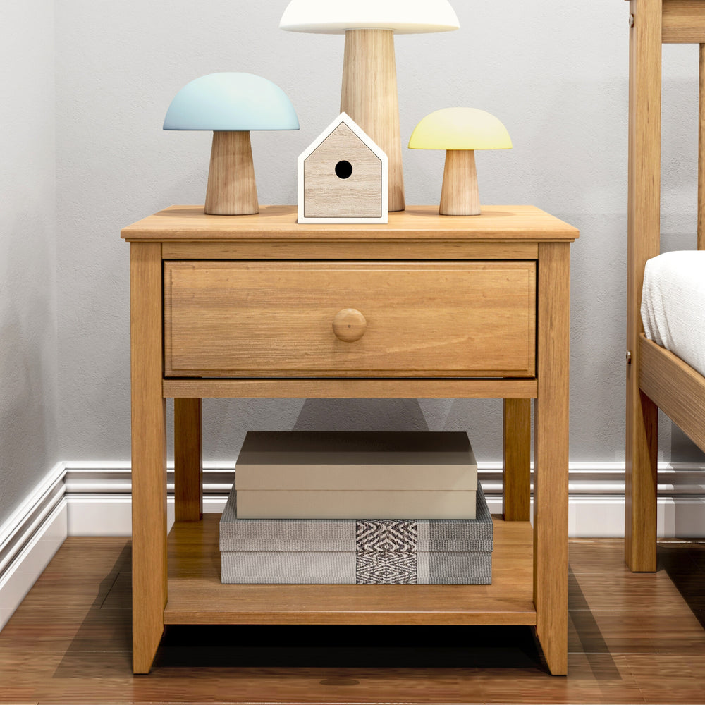 Max and Lily Night Stand With Drawer and Shelf in Pecan - in a bedroom corner with lamps and a birdhouse on top and storage boxes on the lower shelf