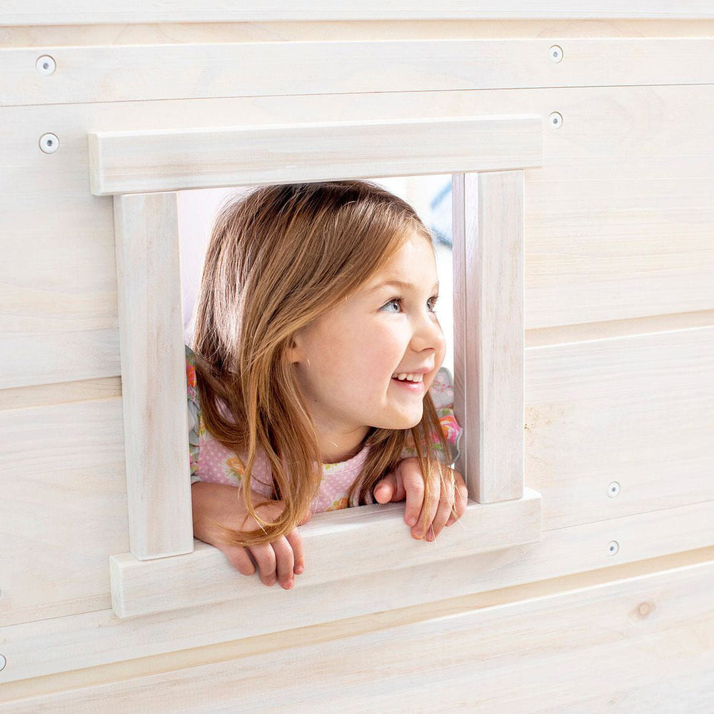 Max and Lily Solid Wood Play and Store Low Loft in White - a smiling girl peeking through the built-in playhouse window panel