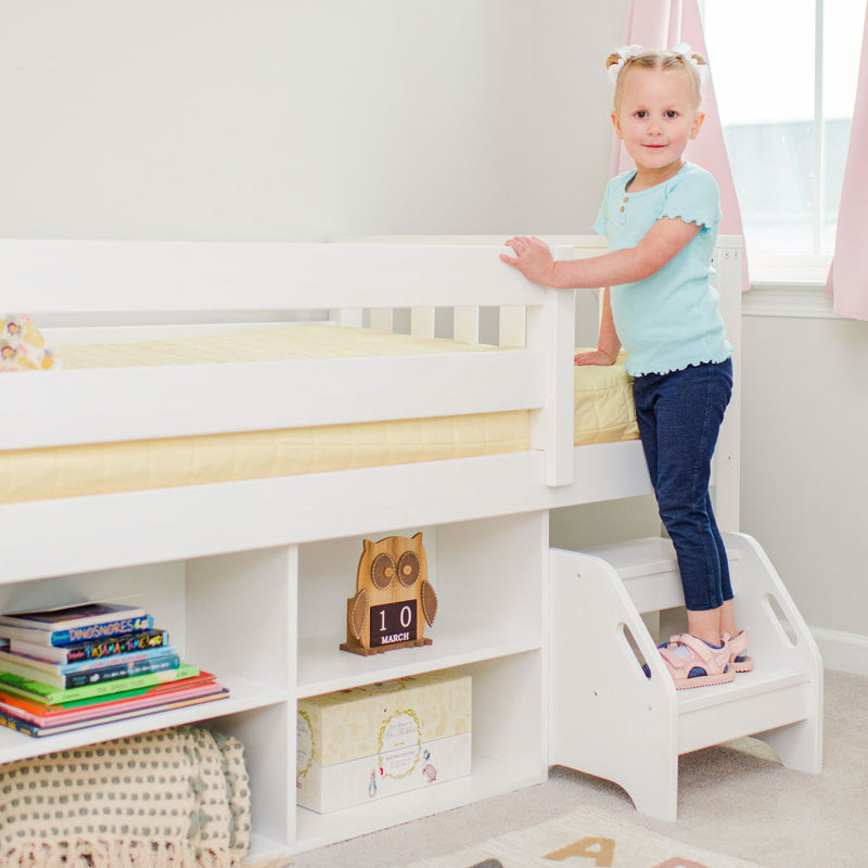 Max and Lily Soren Twin Ultra Low Loft Bed With Bookcase in white - young child standing on the two-step stool to climb into the bed beside the storage bookcase.