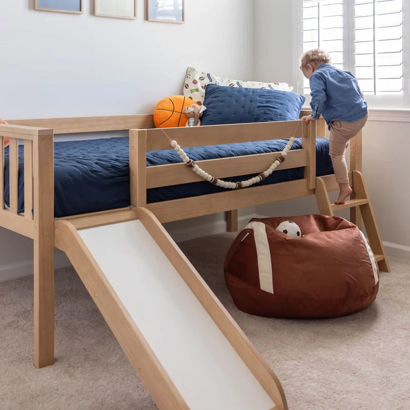 Max And Lily Soren Twin Ultra Low Loft Bed With Slide Blonde Kids Playing Max and Lily Soren Twin Ultra Low Loft Bed With Slide in Blonde - a young child climbing the ladder onto the bed with the attached slide and sports decor in the room