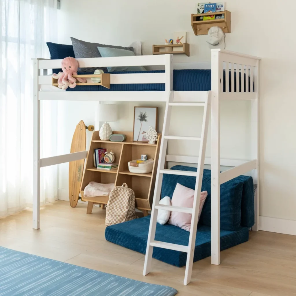 Max and Lily Twin High Loft Bed in White - styled kids' room scene with safety guardrails, angled ladder, and a cozy reading nook with bookshelf and floor cushions under the bed
