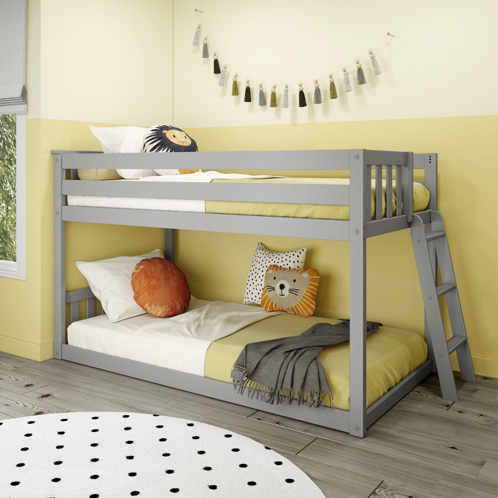 Max And Lily Twin Low Bunk Bed With Ladder On End Grey Room Scene 1 Max And Lily Twin Low Bunk Bed with Ladder on End in Grey - angled view of the low bunk styled in a kids' bedroom with slatted guardrails and a ladder on the end.