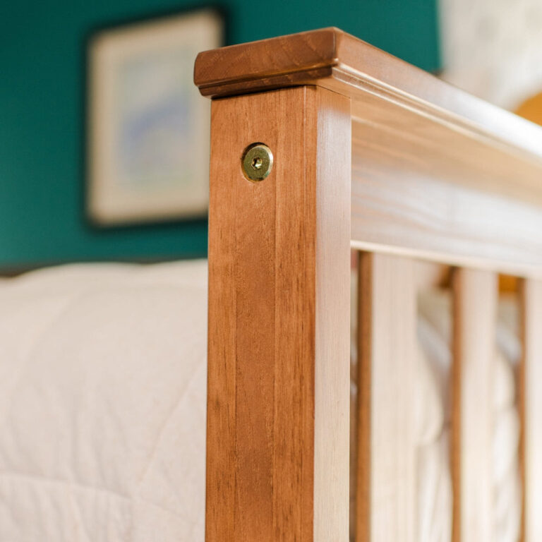 Max And Lily Twin Over Full Bunk Bed With Storage Pecan Finish Closeup Max and Lily Twin Over Full Bunk Bed with Storage in Pecan - closeup of the solid wood corner post and guardrail joinery showing the finish