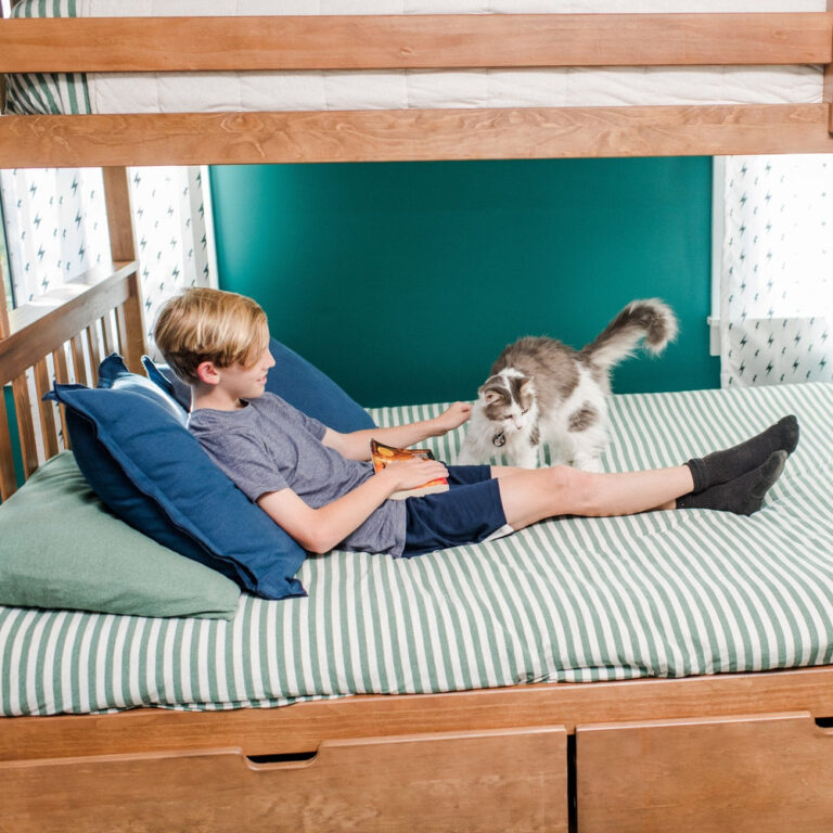 Max And Lily Twin Over Full Bunk Bed With Storage Pecan Kid Relaxing With Cat Max and Lily Twin Over Full Bunk Bed with Storage in Pecan - boy relaxing with a cat on the full-size lower bunk above the storage drawers