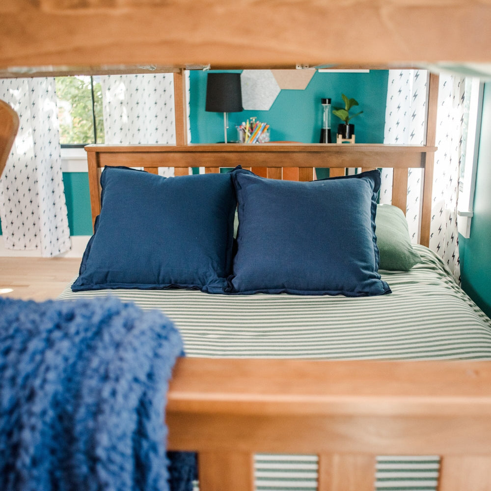 Max And Lily Twin Over Full Bunk Bed With Storage Pecan Lower Bunk Detail Max and Lily Twin Over Full Bunk Bed with Storage in Pecan - close view of the full-size lower bunk headboard and pillows beneath the top bunk