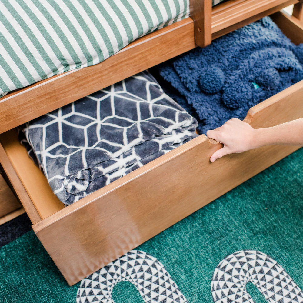 Max And Lily Twin Over Full Bunk Bed With Storage Pecan Storage Drawer Open Max and Lily Twin Over Full Bunk Bed with Storage in Pecan - hand pulling open an under-bed storage drawer filled with blankets