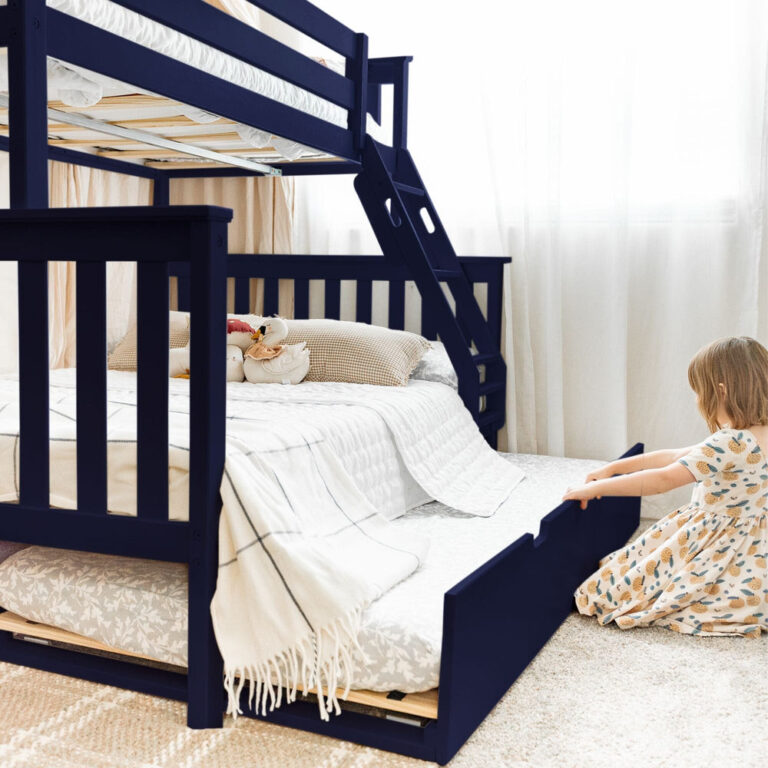 Max and Lily Twin Over Full Bunk Bed with Trundle in Blue - young girl pulling the roll-out trundle bed from under the full-size lower bunk