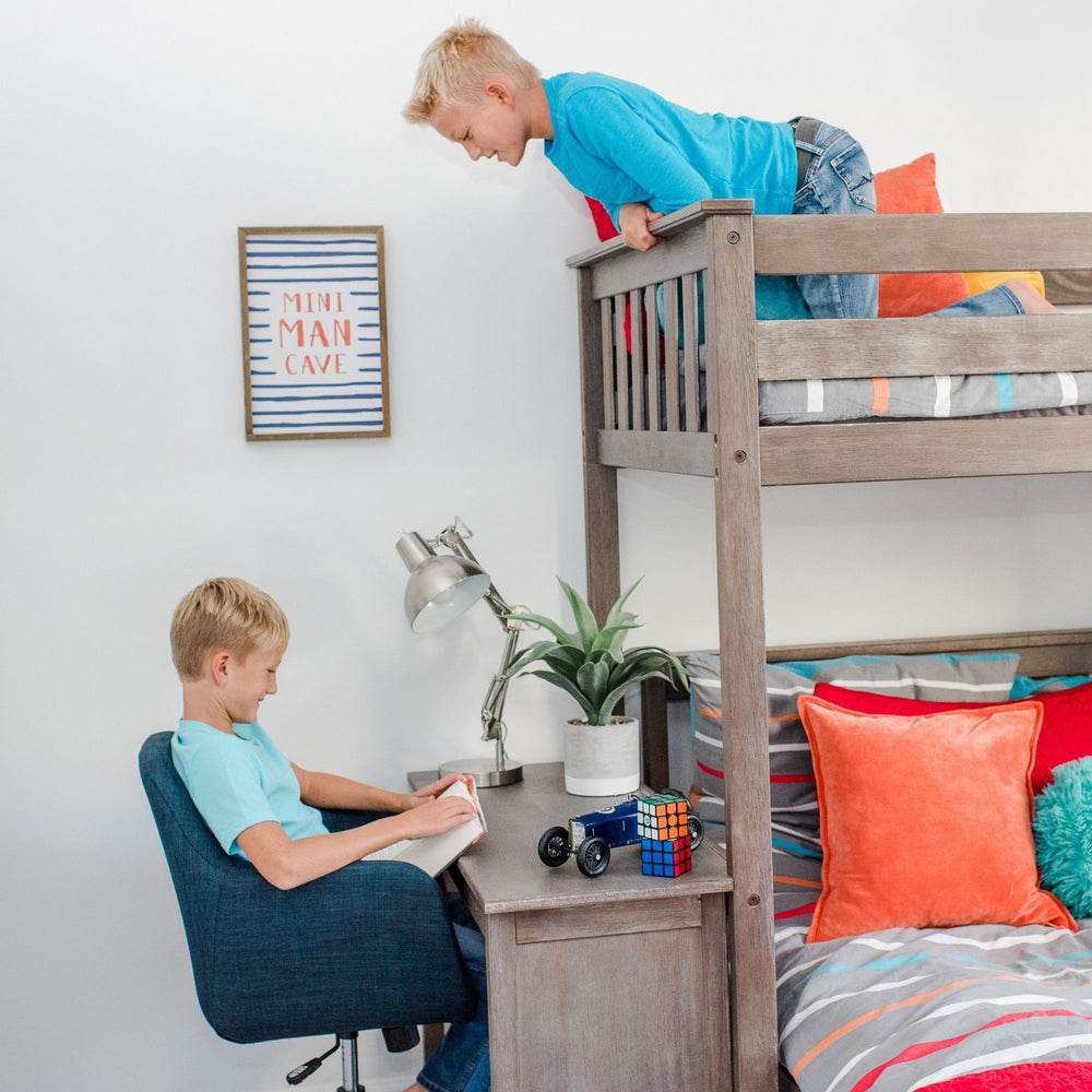 Max and Lily Twin Over Full L-Shaped Bunk Bed With Desk in Clay - two children using the bed, one leaning over the top bunk guardrail while the other reads at the built-in desk