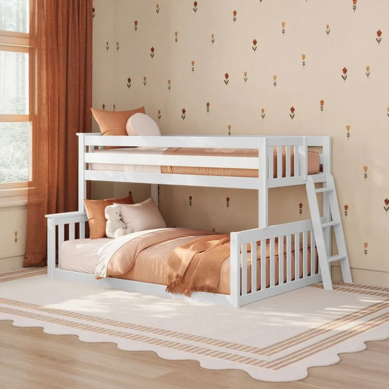 Max and Lily Twin Over Full Low Bunk Bed in White - styled in a child's bedroom with pillows, a teddy bear, and a woven throw, shown at an angle with the ladder on the right.