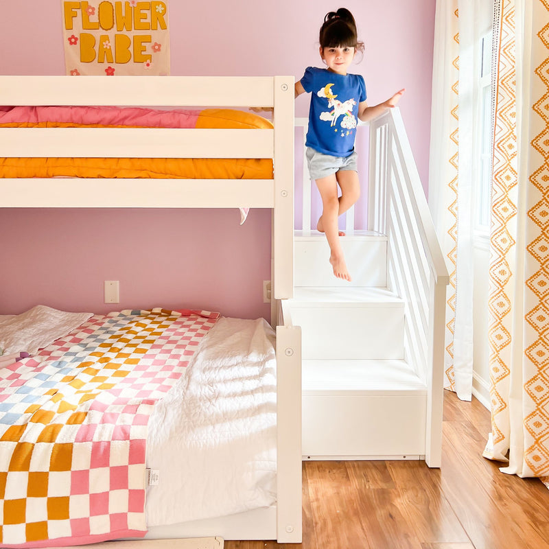 Max And Lily Twin Over Full Low Bunk Bed With Stairs White Kids Playing Max and Lily Twin Over Full Low Bunk Bed With Stairs in White - a child stepping down the built-in staircase beside the made-up bunk bed