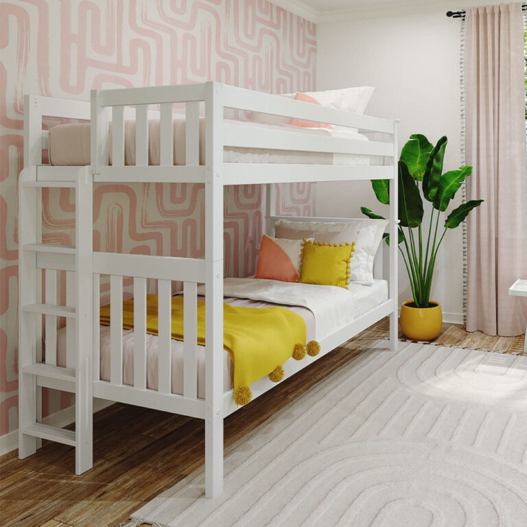 Max and Lily Twin Over Twin Bunk Bed with Ladder on End in White - angled view of the full bunk bed with the ladder on the end, styled in a children's bedroom with pink wallpaper and a leafy plant