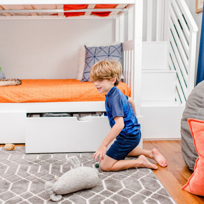Max And Lily Twin Over Twin Bunk Bed With Stairs Storage Drawers White Storage Drawers Open Max and Lily Twin Over Twin Bunk Bed With Stairs & Storage Drawers in white - a boy beside the bed with a lower storage drawer pulled open.
