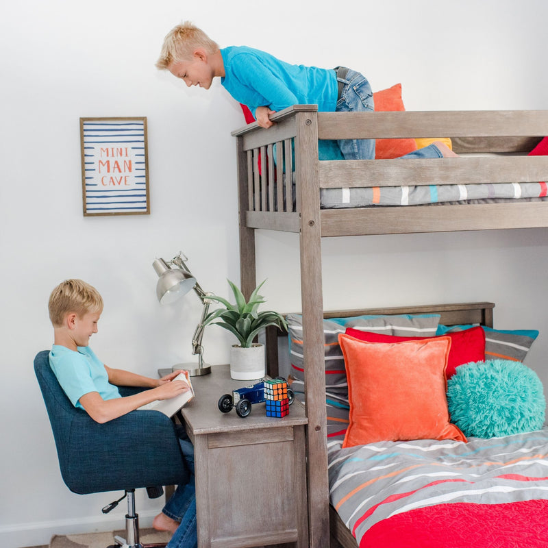 Max and Lily Twin Over Twin L-Shaped Bunk Bed With Desk in Clay - one child climbing onto the top bunk while another reads at the attached desk with a lamp.