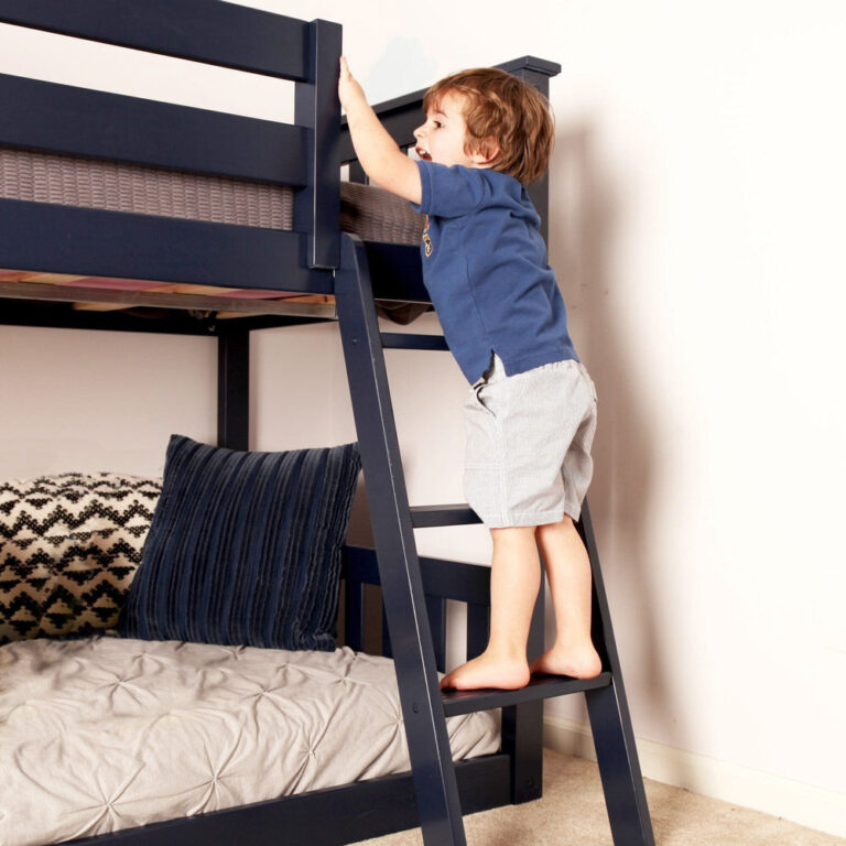 Max And Lily Twin over Twin Low Bunk Bed in Blue - young child climbing the angled ladder to the guarded top bunk