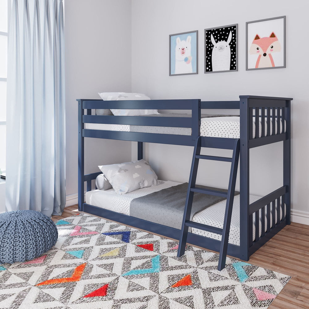 Max And Lily Twin over Twin Low Bunk Bed in Blue - low bunk with full-length safety guardrails and angled ladder styled in a kids room with a geometric rug and wall art