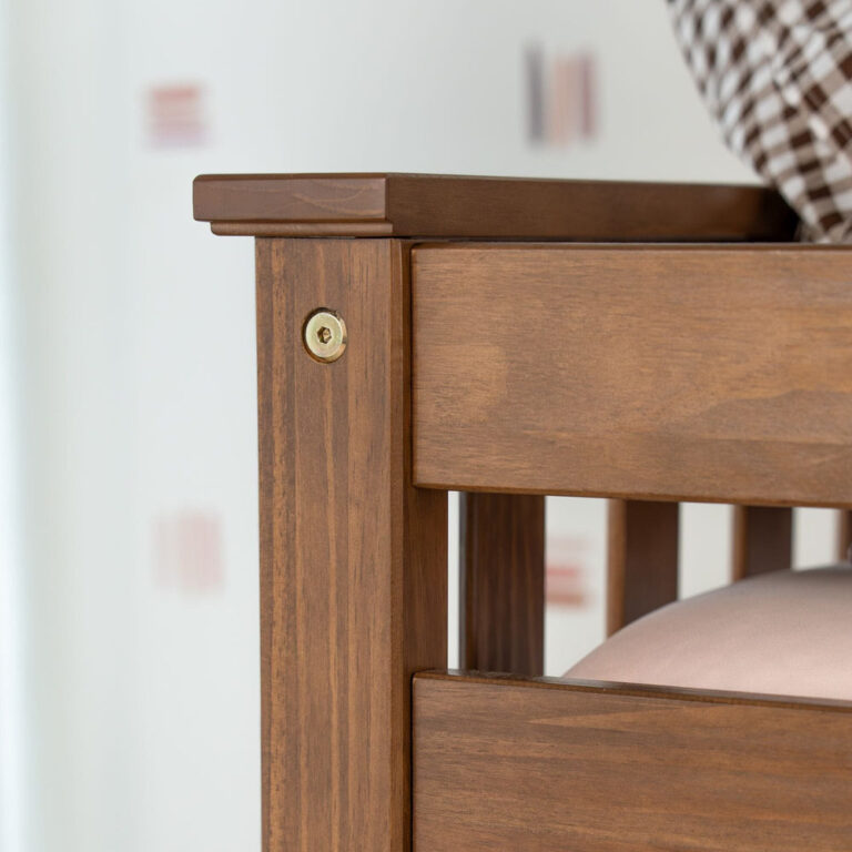 Max And Lily Twin over Twin Low Bunk Bed in Pecan - closeup of the corner post and upper guardrail joint with recessed brass hardware