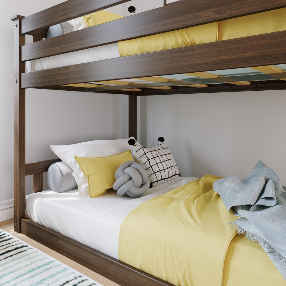 Max And Lily Twin over Twin Low Bunk Bed in Walnut - closeup of the upper bunk guardrail and wood slats above the made-up lower bed