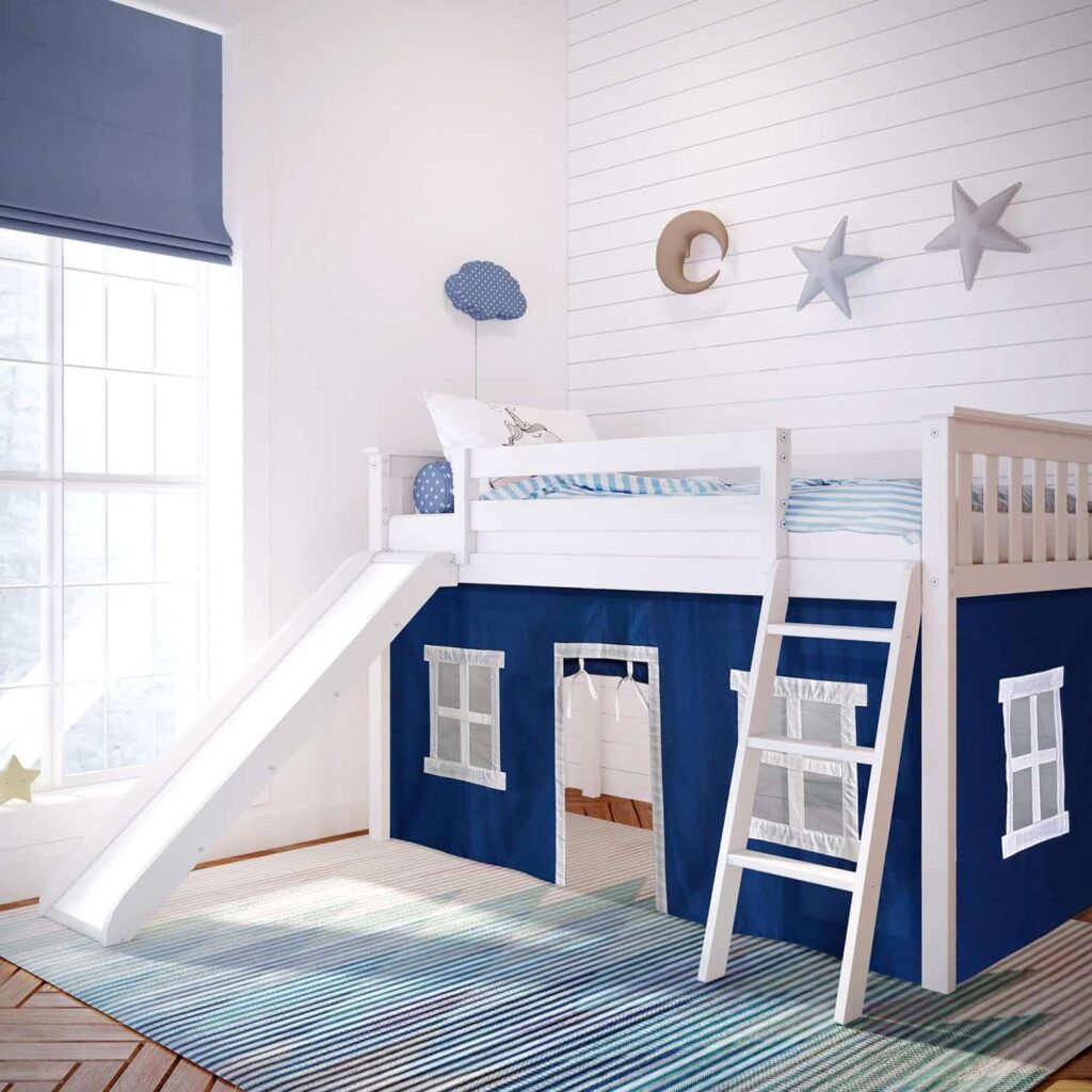 Max and Lily Twin-Size Low Loft Bed With Slide And Curtain in Blue/White - room scene showing the white bed with slide and ladder set up in a child's bedroom with a striped rug and star wall decor.