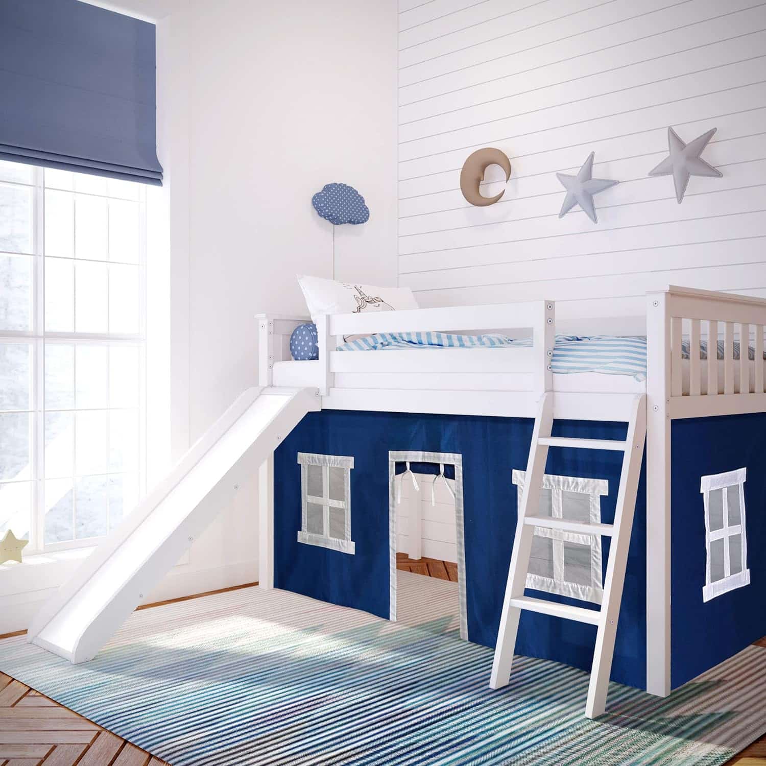 Max and Lily Twin-Size Low Loft Bed With Slide And Curtain in Blue/White - room scene showing the white bed with slide and ladder set up in a child's bedroom with a striped rug and star wall decor.