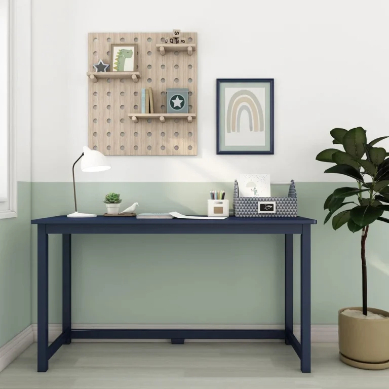 Max and Lily Writing Desk in Blue - shown front-on against a green wall with a desk lamp, pencil holder and framed rainbow wall art.