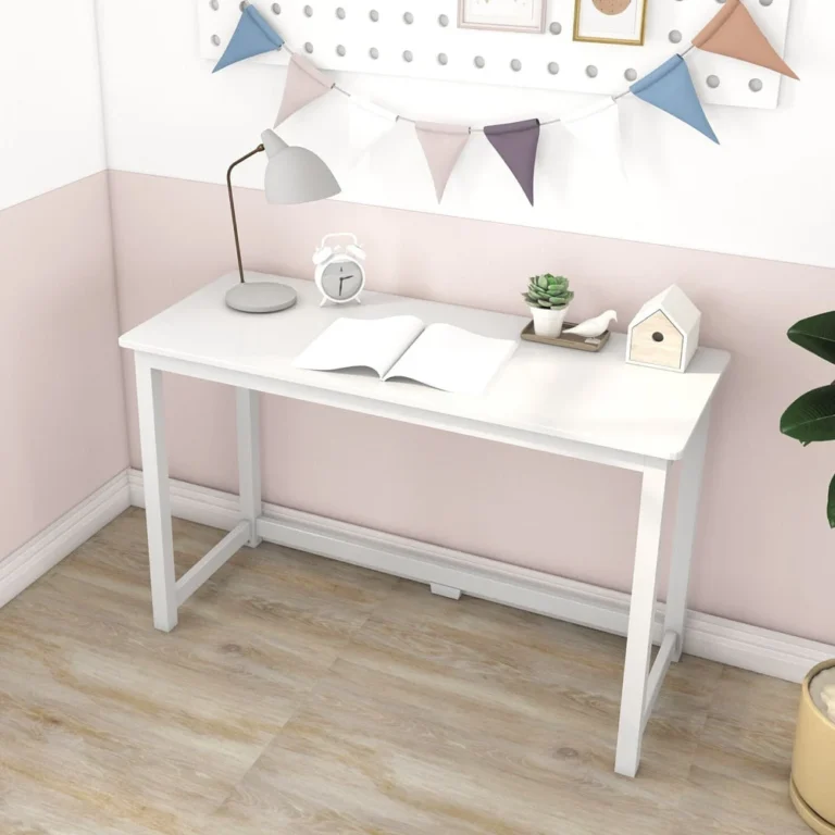 Max and Lily Writing Desk in White - styled in a pink kids room with a desk lamp, alarm clock, open book and potted plant on top