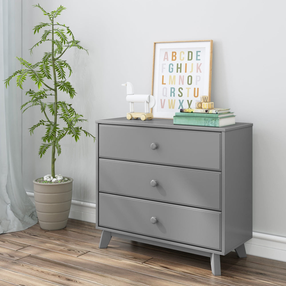 Max & Lily Classic 3 Drawer Dresser in grey - styled in a child's room beside a potted plant with an alphabet print, wooden toy horse, and books arranged on top.