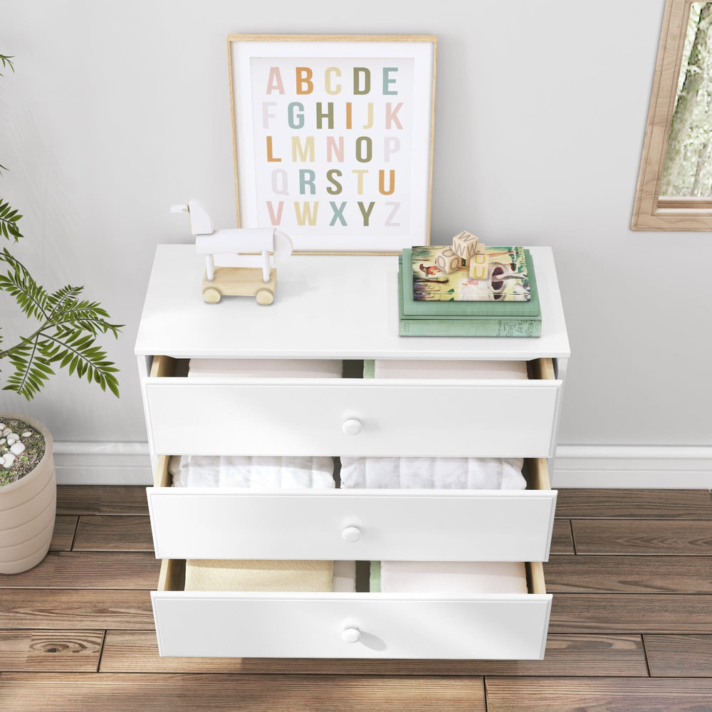 Max & Lily Classic 3 Drawer Dresser in White - all three drawers open showing folded clothing and blankets in a nursery setting.
