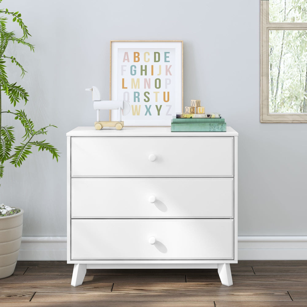 Max & Lily Classic 3 Drawer Dresser in White - front-facing room scene styled with a plant, alphabet print, and books.