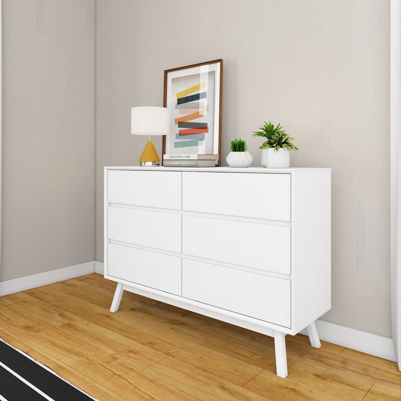 Max Lily Mid Century Modern 6 Drawer Dresser White Room Scene 1 Max & Lily Mid Century Modern 6 Drawer Dresser in White - styled in a bedroom corner with a table lamp, framed art, and potted plants on top.