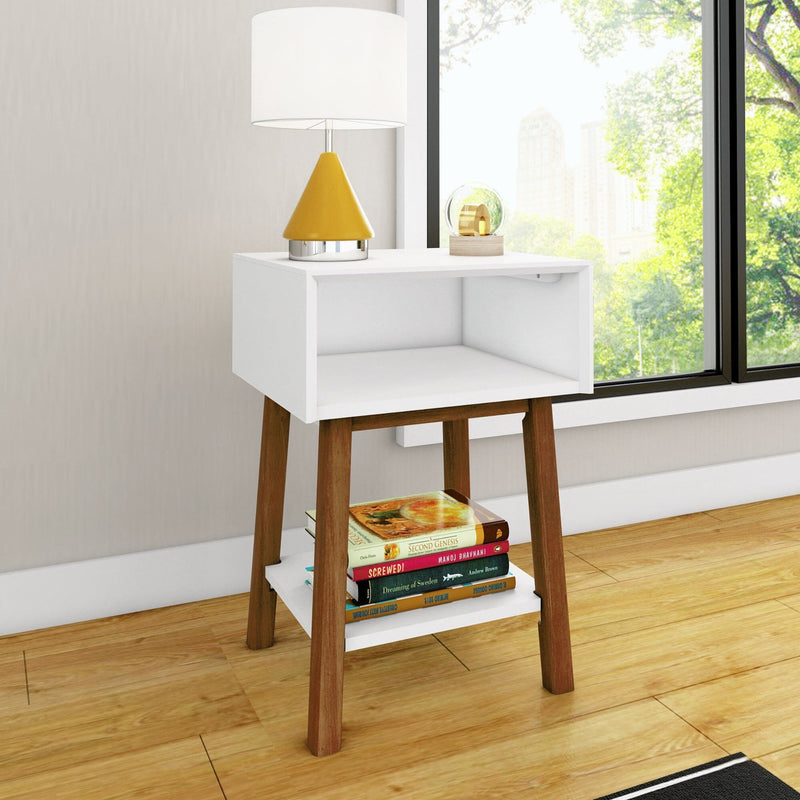 Max & Lily Mid-Century Modern Cubby Night Stand in White/Pecan - styled in a bedroom corner with a lamp on top and books stacked on the lower open shelf beside a bright window