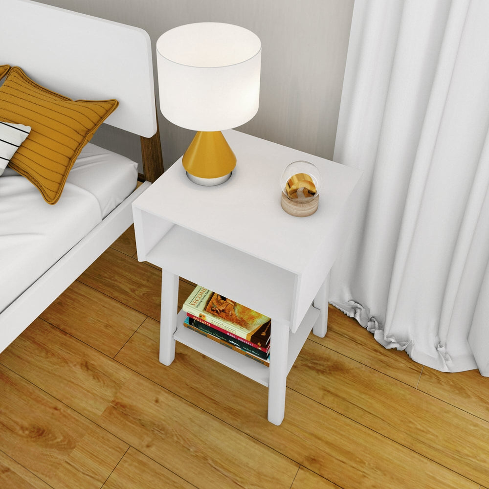 Max & Lily Mid-Century Modern Cubby Night Stand in White - overhead room scene beside a bed with a lamp, decor, and books on the lower shelf.