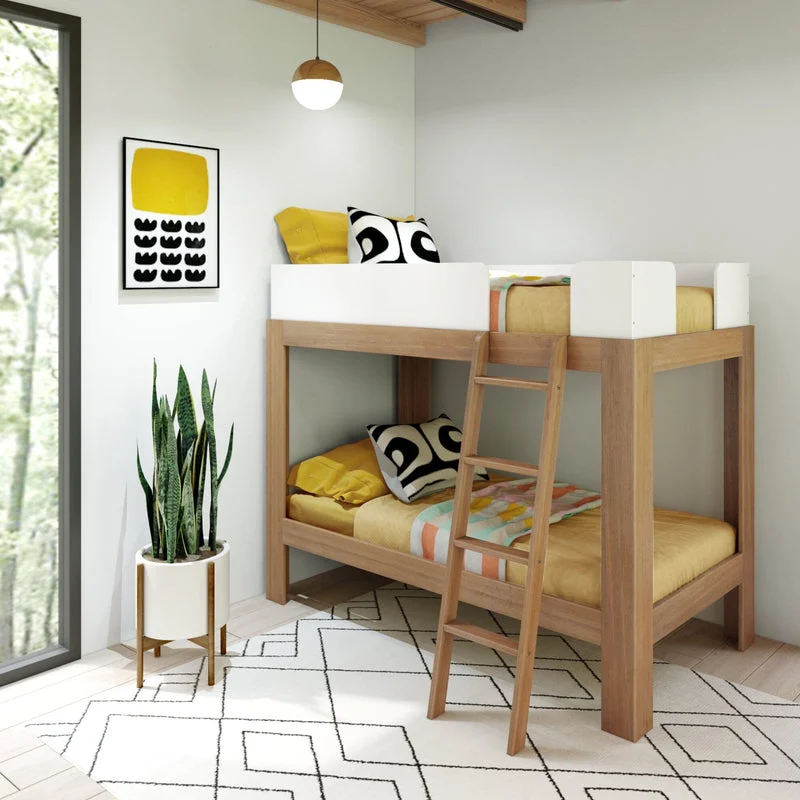 Max & Lily Mid-Century Modern Twin Over Twin Bunk Bed in White/Pecan - angled view in a styled kids room with white guardrail panels, angled ladder, and yellow bedding