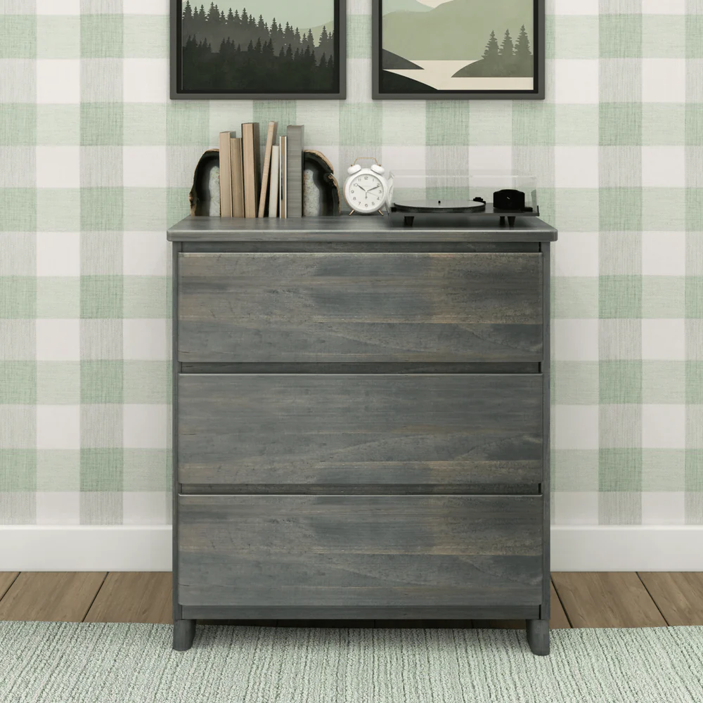 Max & Lily Modern Farmhouse 3 Drawer Dresser in Driftwood - front view in a styled bedroom with books, an alarm clock and a record player on top